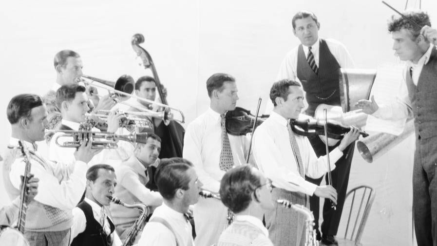 Charlie Chaplin am Dirigentenpult bei einer Probe mit dem Abe Lyman Orchestra (1925).