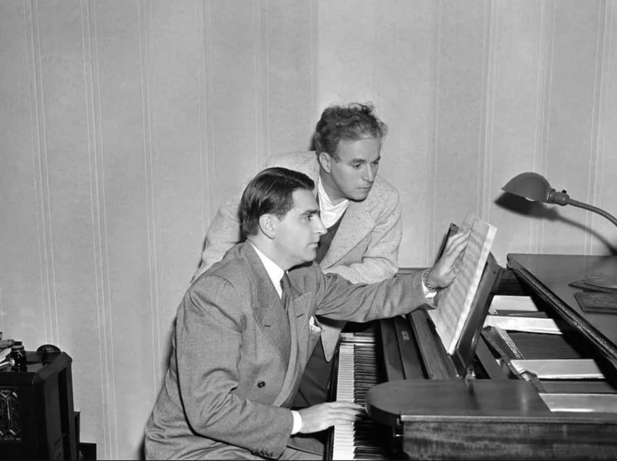 Charlie Chaplin leitet den Komponisten Meredith Willson am Klavier an, bei der Arbeit an der Musik zu „Der grosse Diktator“ (1940).