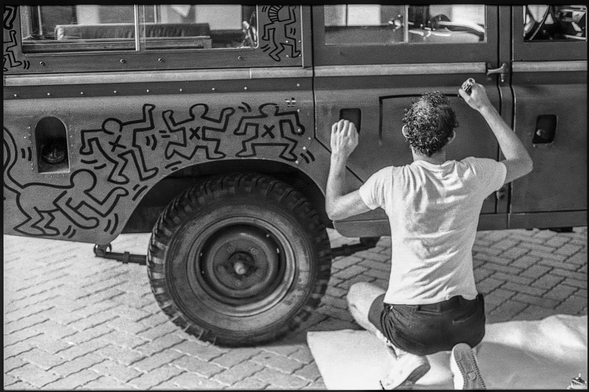 Keith Haring zeichnet auf dem Land Rover, im Juli 1983. Foto Edouard Curchod.