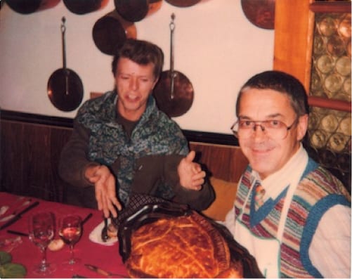 David Bowie e Claude Nobs a tavola nello chalet, davanti a una torta salata.