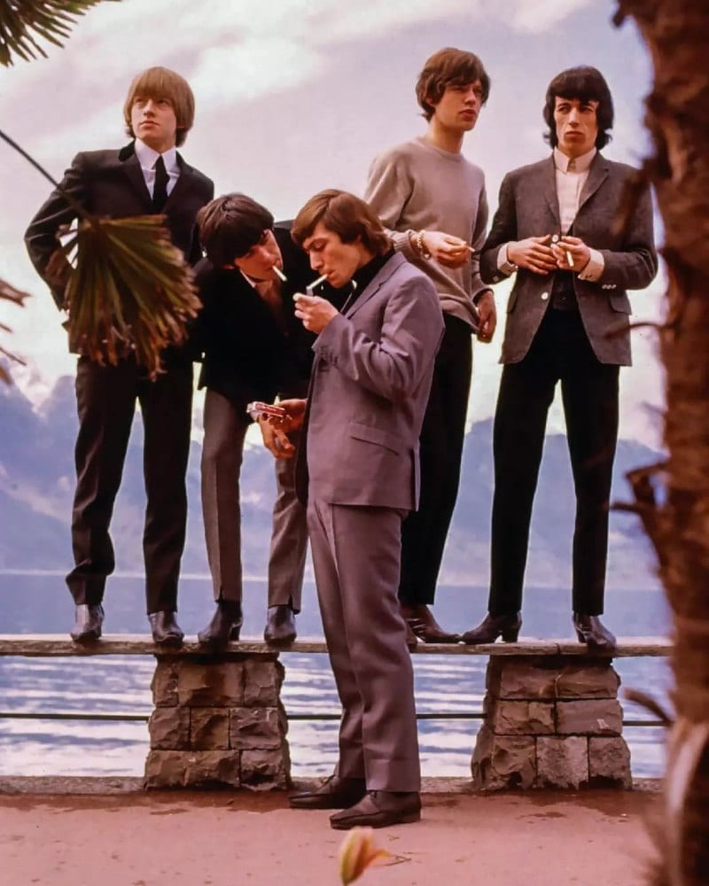 Die Rolling Stones, Zigarette in der Hand, auf der Mauer am Seeufer, im April 1964.