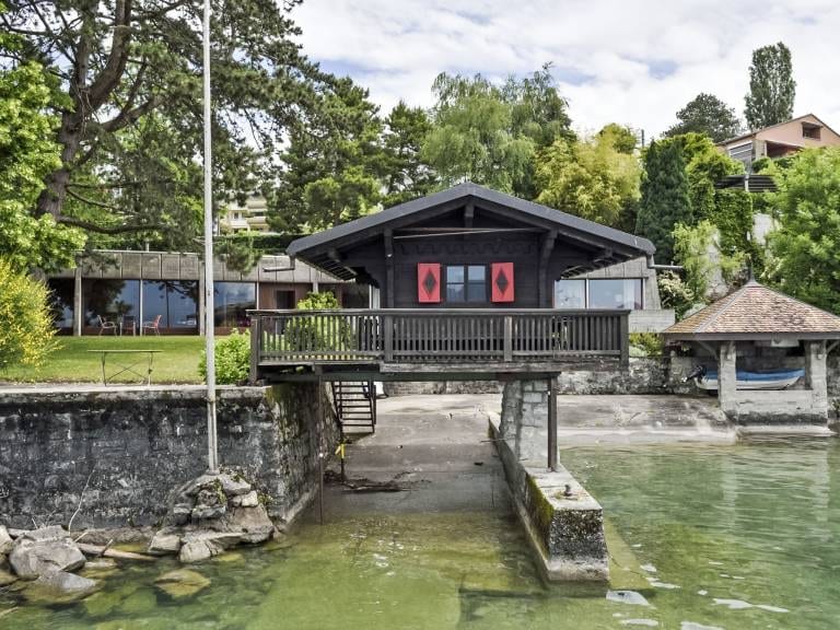 Das Hölzerne Chalet auf Pfahlbauten direkt am Wasser, mit Terrasse zum Genfersee.